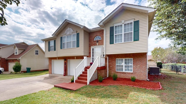 view of front of house with a front yard, central air condition unit, and a garage