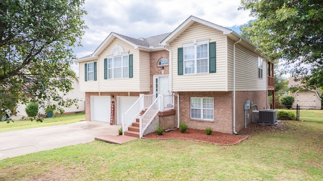 bi-level home with a front yard, central air condition unit, and a garage