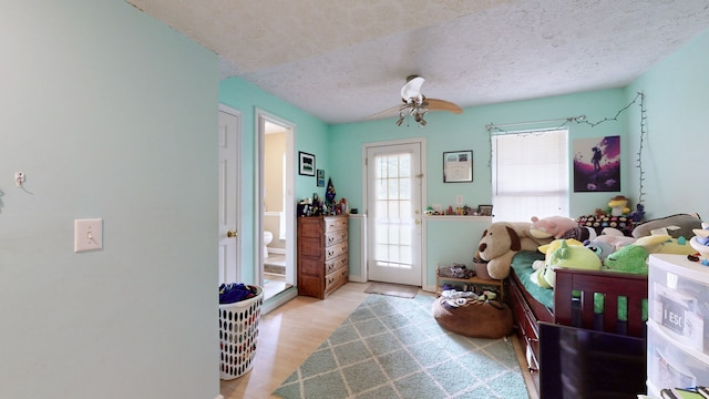 interior space featuring light wood-type flooring, ceiling fan, and a textured ceiling