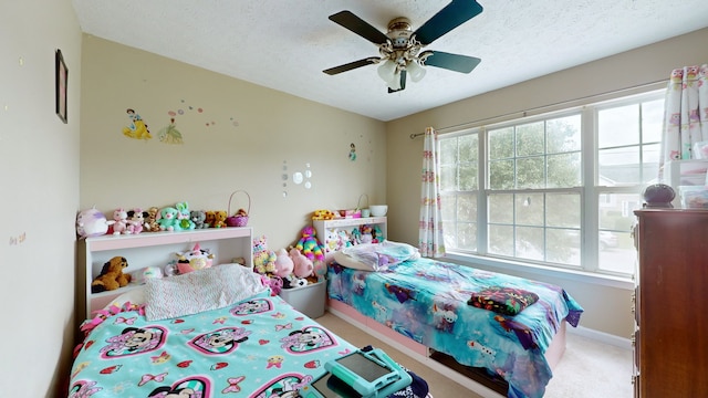 carpeted bedroom featuring a textured ceiling and ceiling fan