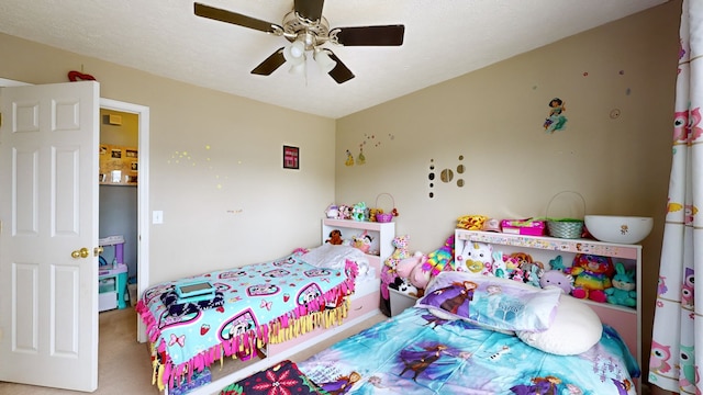 carpeted bedroom featuring a textured ceiling and ceiling fan