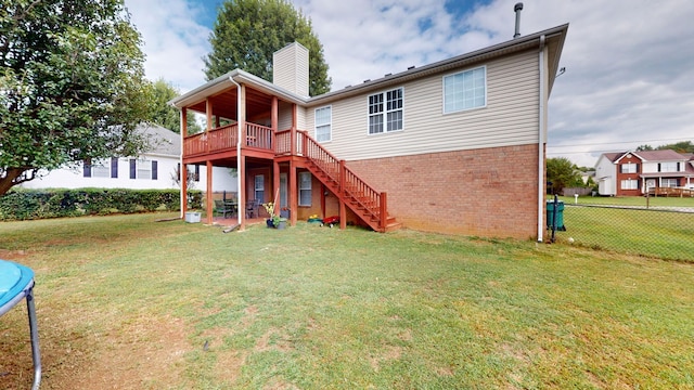 rear view of property with a lawn and a wooden deck