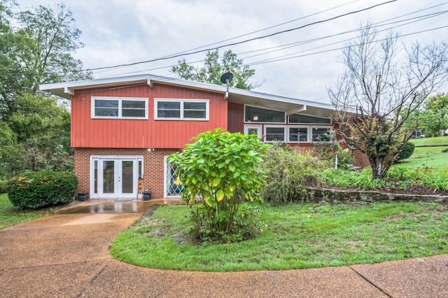 view of front of property featuring french doors and a front lawn