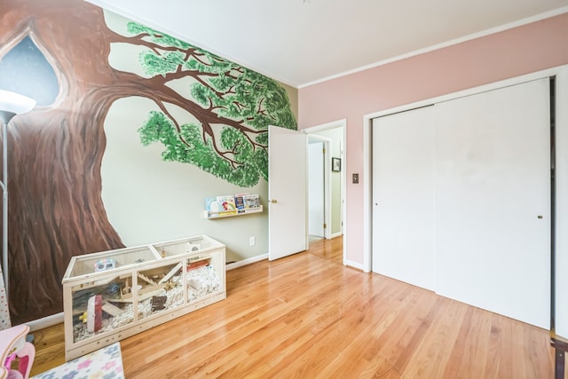 game room featuring wood-type flooring and ornamental molding