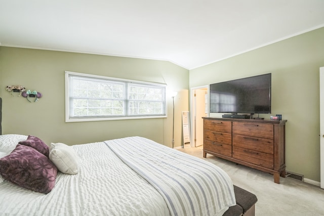 bedroom featuring crown molding, vaulted ceiling, and light colored carpet