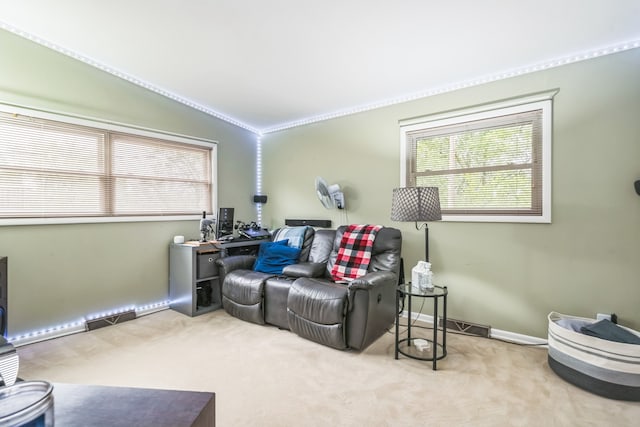 living room with ornamental molding, vaulted ceiling, and light colored carpet