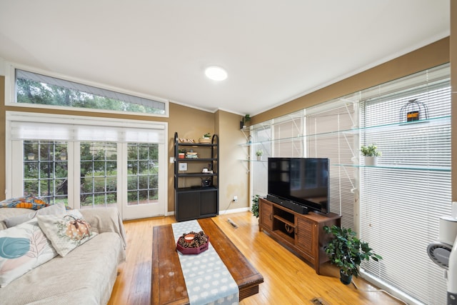 living room with vaulted ceiling, hardwood / wood-style floors, and crown molding