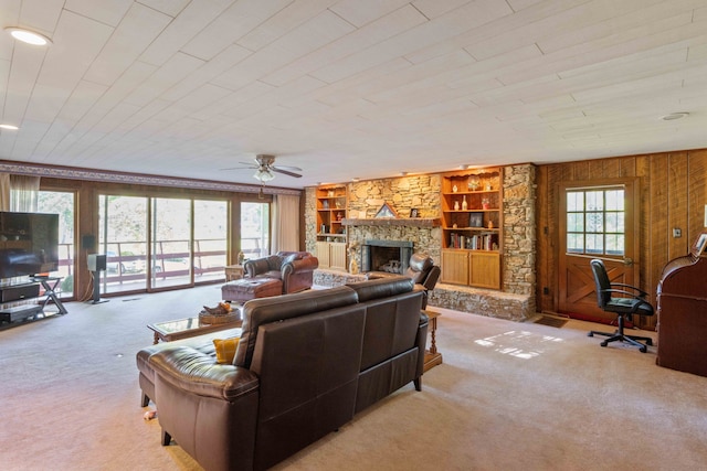 living room with light carpet, wood walls, and a healthy amount of sunlight