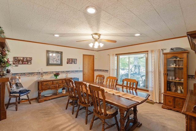 dining space with light carpet, ceiling fan, and ornamental molding