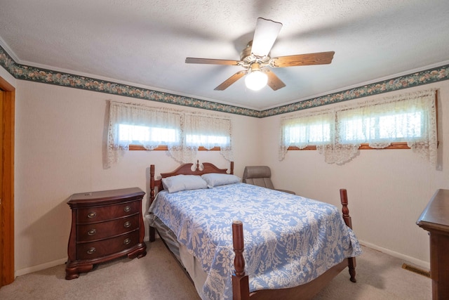 carpeted bedroom featuring ceiling fan and a textured ceiling