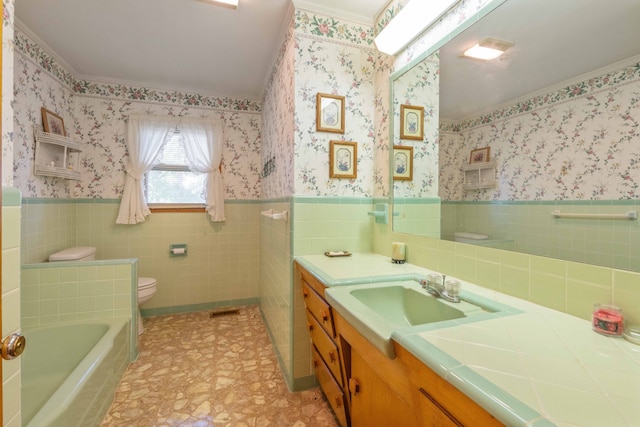 bathroom featuring tile walls, vanity, toilet, ornamental molding, and a washtub