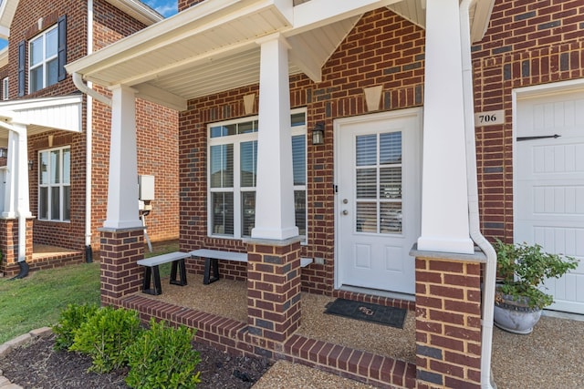 doorway to property with a porch and a garage