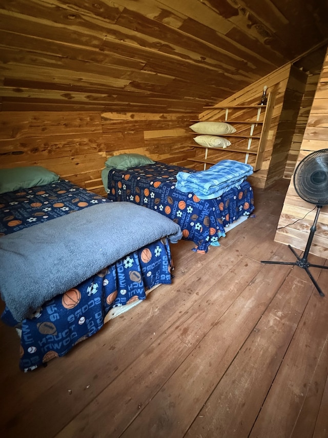 bedroom with wooden walls, wooden ceiling, and hardwood / wood-style floors