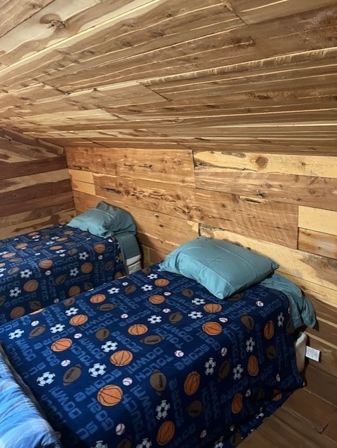 unfurnished bedroom featuring hardwood / wood-style flooring, lofted ceiling, wood walls, and wooden ceiling