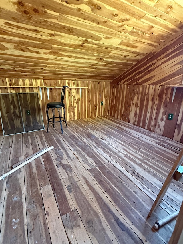 interior space with wood ceiling, wooden walls, lofted ceiling, and hardwood / wood-style floors