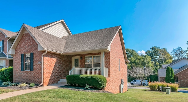 view of front of house with covered porch and a front lawn