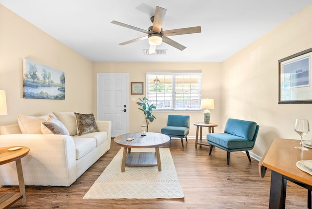 living room with wood-type flooring and ceiling fan