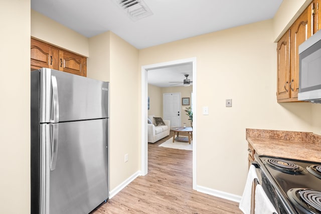 kitchen with ceiling fan, appliances with stainless steel finishes, and light hardwood / wood-style floors