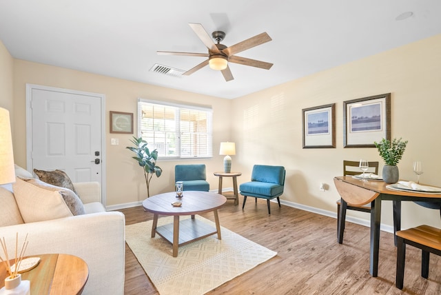 living room with light hardwood / wood-style flooring and ceiling fan