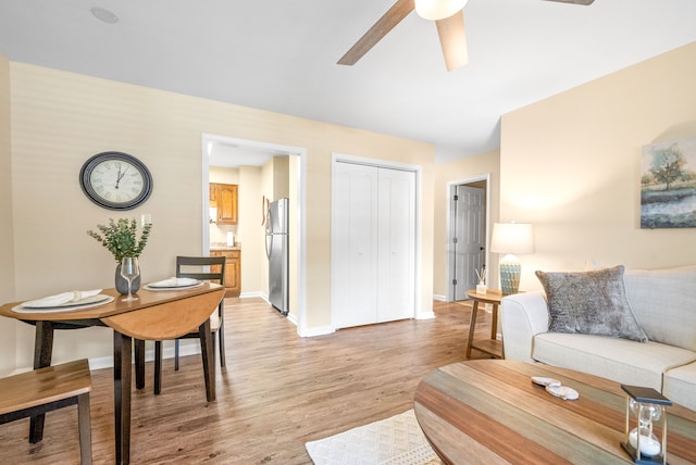 living room with ceiling fan and light hardwood / wood-style floors