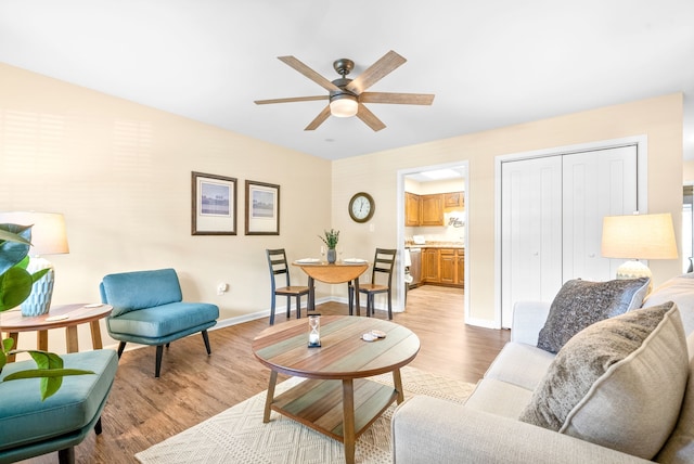 living room featuring light wood-type flooring and ceiling fan