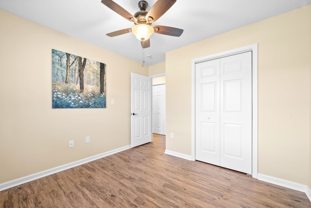 unfurnished bedroom featuring ceiling fan, a closet, and light hardwood / wood-style flooring