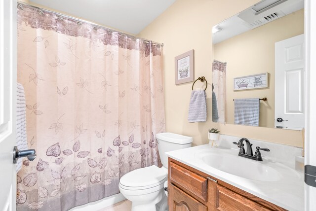 bathroom featuring walk in shower, vanity, and toilet