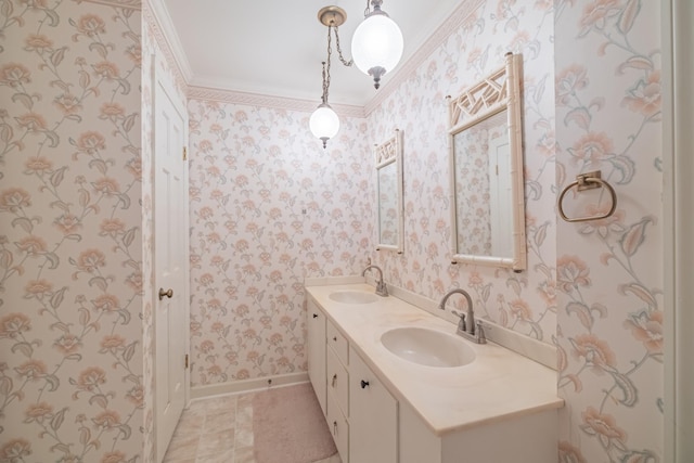 full bath with a sink, baseboards, double vanity, and wallpapered walls