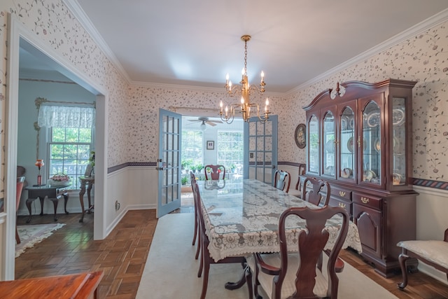 dining space with ceiling fan with notable chandelier, dark parquet flooring, and crown molding