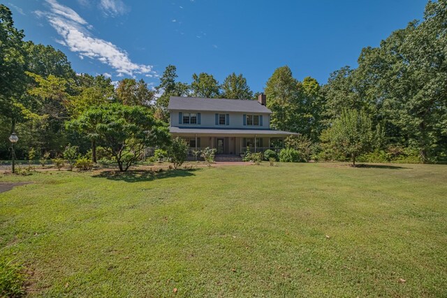 view of front facade with a porch, a chimney, and a front lawn