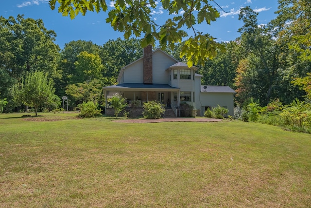 back of house featuring a yard and covered porch