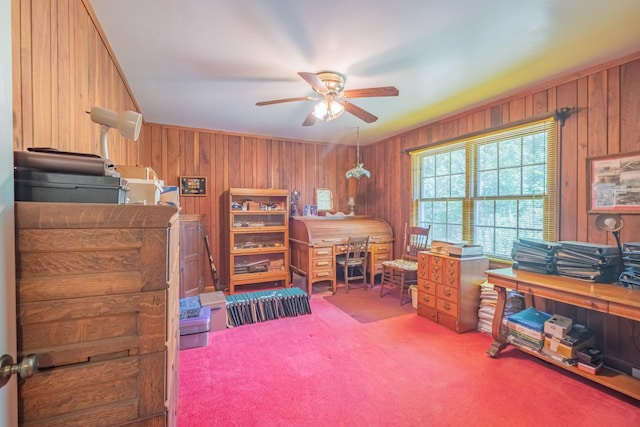 office space with wood walls, a ceiling fan, and carpet