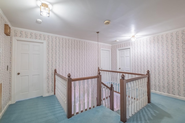 hallway with baseboards, wallpapered walls, ornamental molding, an upstairs landing, and carpet floors