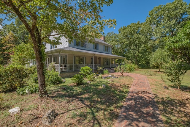 back of property featuring a chimney and covered porch