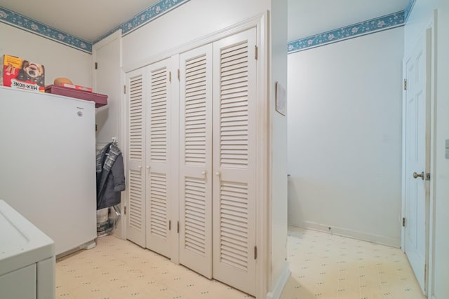 laundry area with tile patterned floors and baseboards