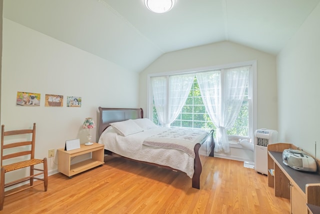bedroom with light wood-type flooring and lofted ceiling