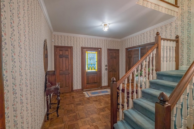 foyer entrance with ornamental molding, baseboards, stairway, and wallpapered walls
