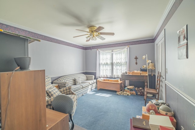 interior space with carpet flooring, crown molding, a wainscoted wall, and ceiling fan