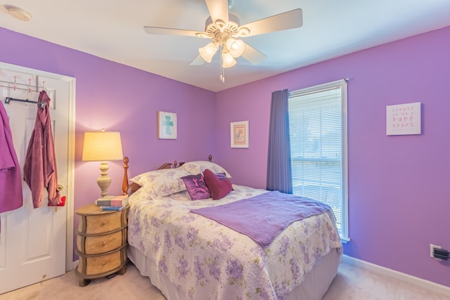 bedroom featuring multiple windows, light carpet, and ceiling fan