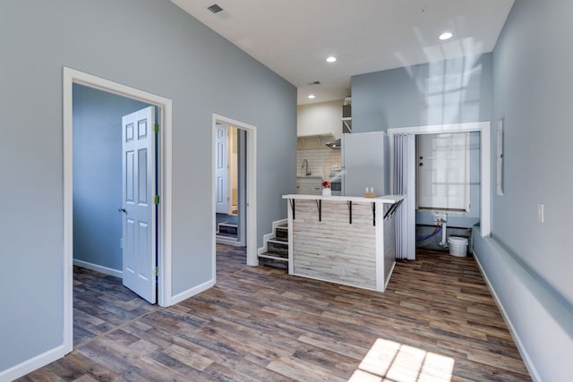 kitchen with decorative backsplash, sink, dark wood-type flooring, and a breakfast bar