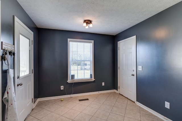 tiled foyer with a textured ceiling