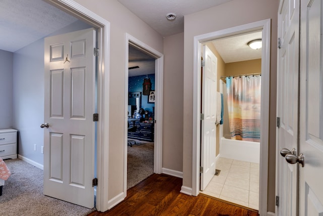 hallway featuring a textured ceiling and dark wood-type flooring