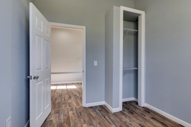 unfurnished bedroom with a closet and dark hardwood / wood-style floors