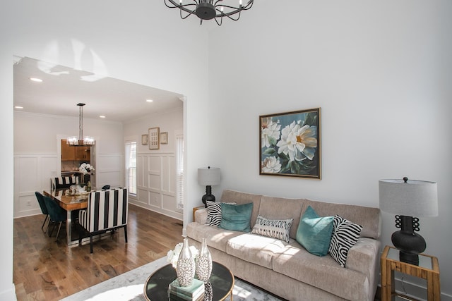 living room with hardwood / wood-style flooring, crown molding, and a chandelier