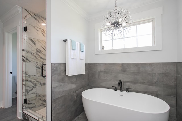 bathroom with plus walk in shower, crown molding, a chandelier, and tile walls