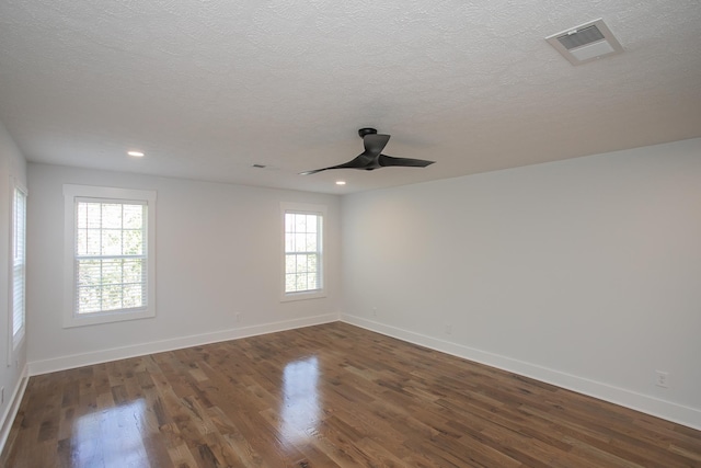 spare room featuring a textured ceiling, ceiling fan, and dark wood-type flooring