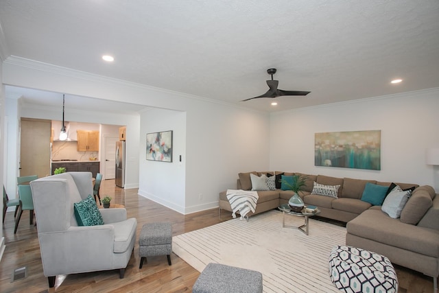 living room featuring ornamental molding, ceiling fan, and hardwood / wood-style flooring