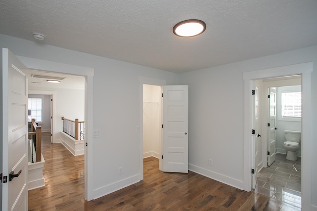 bedroom featuring a spacious closet, a closet, multiple windows, and dark hardwood / wood-style floors