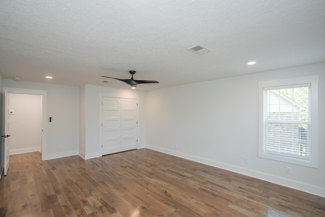 spare room featuring ceiling fan, a textured ceiling, and dark hardwood / wood-style flooring