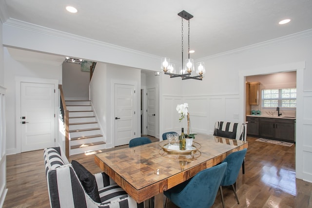 dining space with crown molding, dark hardwood / wood-style flooring, sink, and a notable chandelier